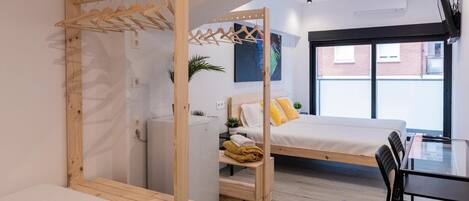 Un dormitorio moderno con un cabecero de madera, una mesita de noche pequeña, un banco y un perchero.