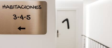 A hotel sign indicating room numbers 3-4-5 with an arrow pointing left.