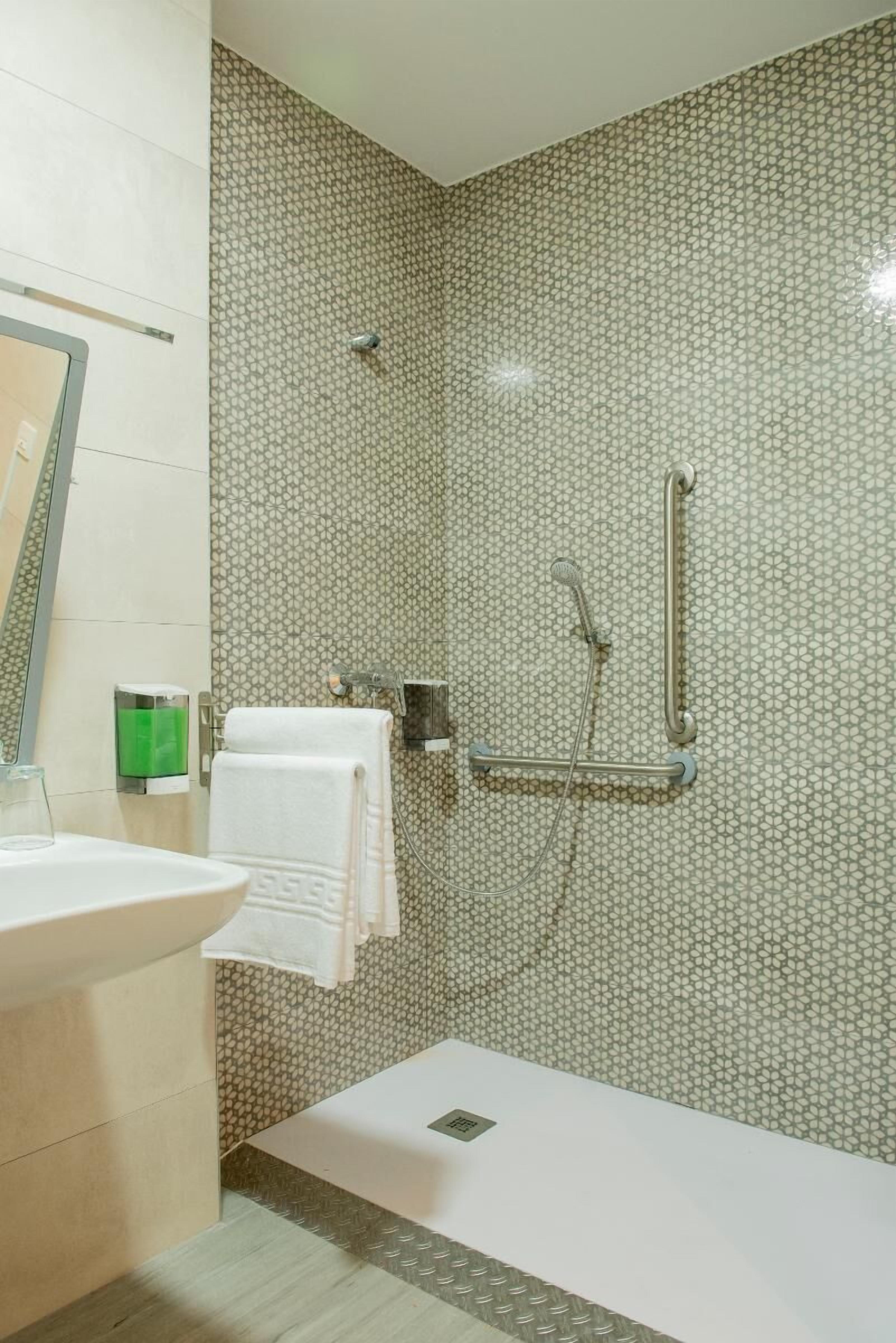 A bathroom with a shower, a sink, and a toilet.