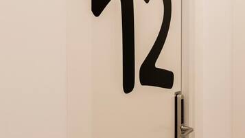 Une porte sur laquelle est apposé un grand numéro noir, le chiffre « 12 ».
