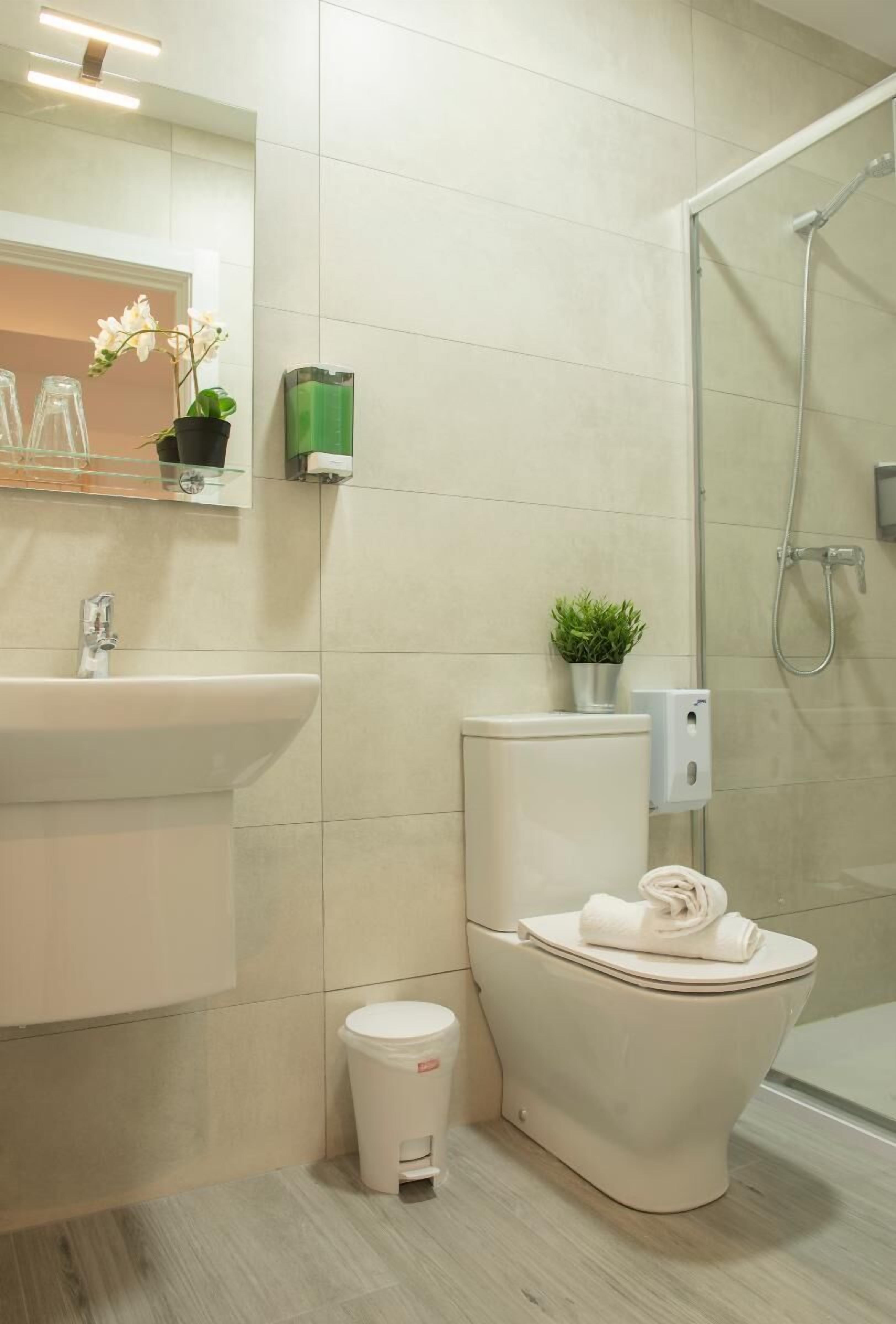 A modern bathroom with a toilet, sink, and shower.