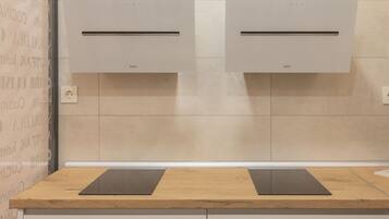 Una cocina moderna con dos hornos empotrados, una encimera de madera y un mueble bajo.