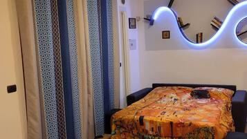 Un dormitorio con una cama, cortinas, un reloj de pared y una estantería.