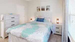 Un dormitorio con cama, cómoda, mesita de noche y decoración en la pared.
