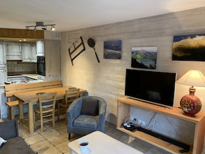 Een ruimtelijke woonkamer met een keuken, eethoek en zithoek.