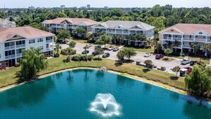 A residential complex with multiple two-story houses, a central swimming pool with a fountain, and a parking area. - XXXXXXXXXX (North Myrtle Beach)