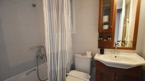 A bathroom with a bathtub, toilet, and sink. - Seven Seconds Away (Athens)