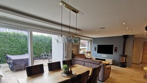 Una sala de estar moderna con sofá, mesa de comedor y televisor.