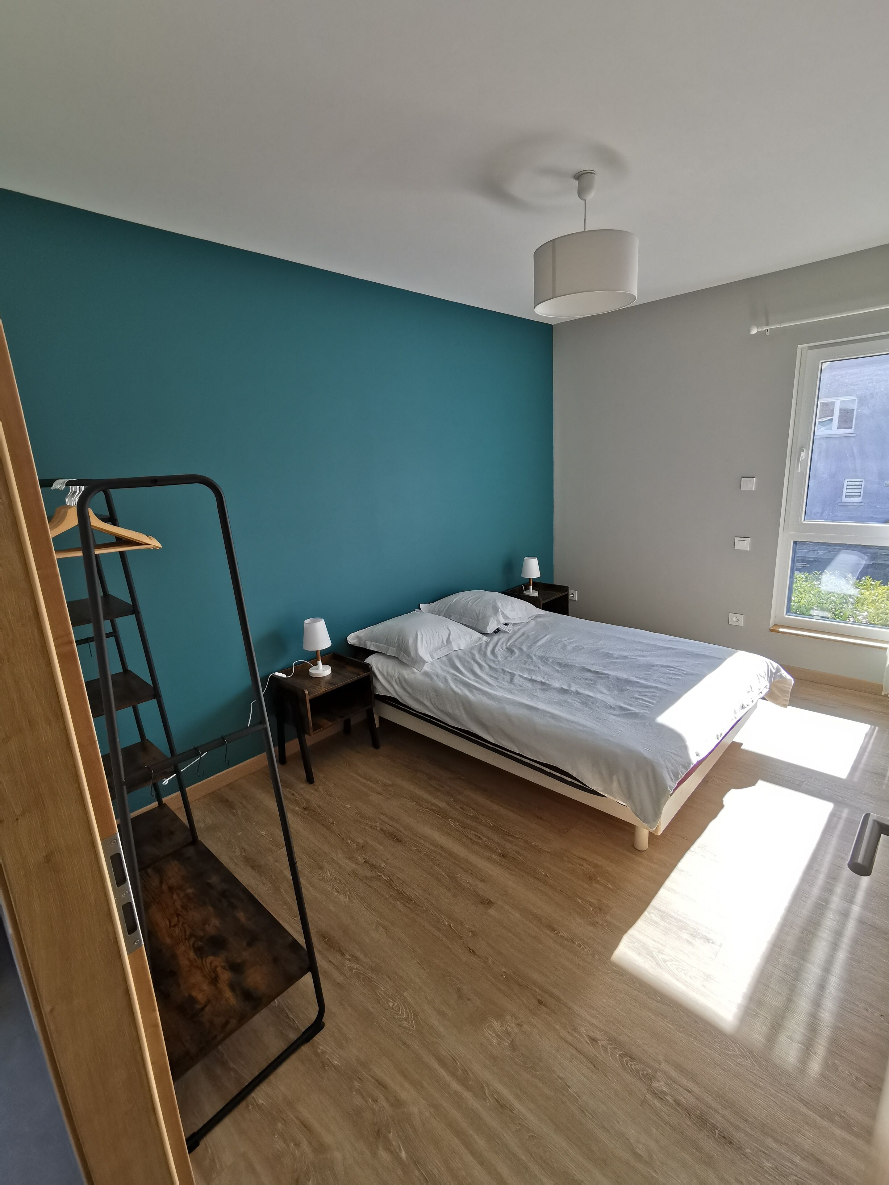 Ein Schlafzimmer mit einem Bett, einem Nachttisch, einem Schreibtisch und einem Stuhl.