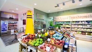 Une épicerie proposant des fruits et légumes frais de saison, un rayon de produits de la mer et une zone de caisses.