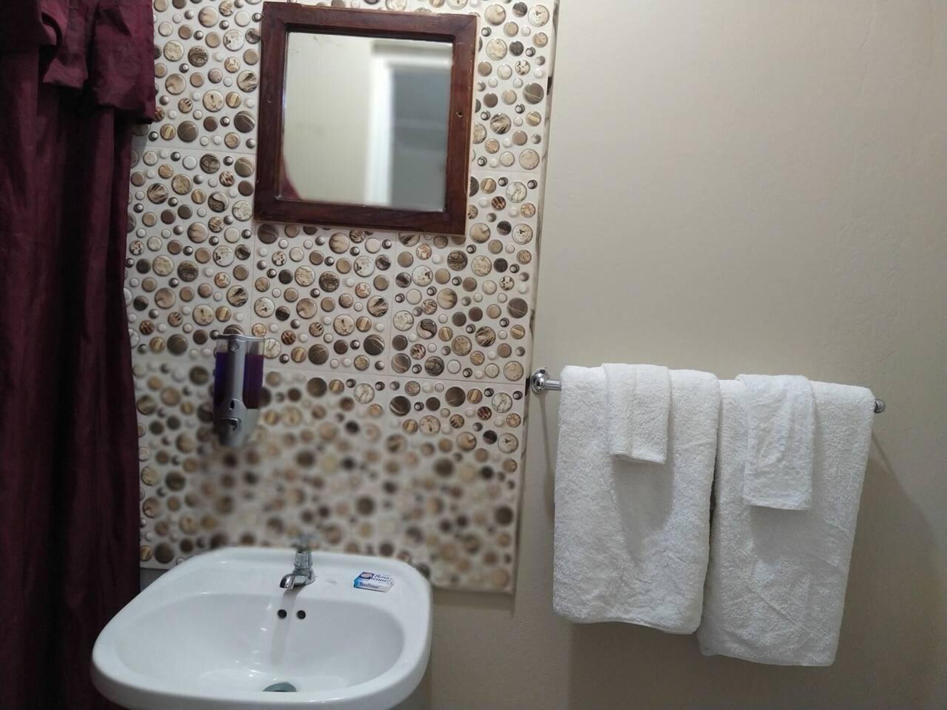 A bathroom with a sink, mirror, and towel rack.