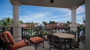Relax on the balcony with a round table and four comfortable chairs, taking in the view of the surrounding residential area.