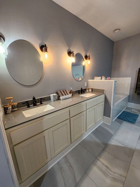 A modern bathroom with a double sink vanity, a large mirror, and wall-mounted lighting. - Country Comfort and Views - 10 minutes from restaurants. (Newburgh)