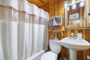 Bathtub, hair dryer, towels, shampoo