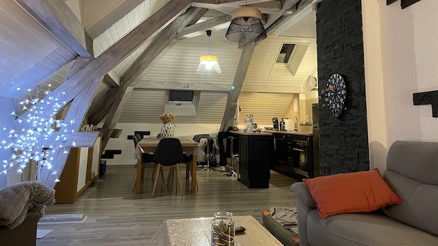 A loft-style living space with exposed wooden beams, a dining area, and a kitchen. - Loft near Gerardmer (Corcieux)