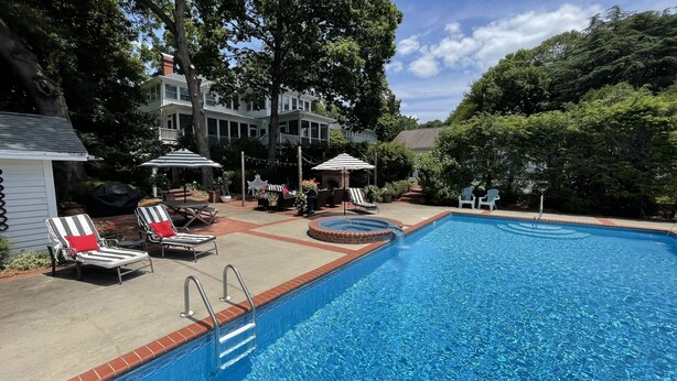 A swimming pool with lounge chairs and a barbecue area. - Downtown Hickory Lounge (Hickory)