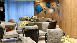 Ein modernes Wohnzimmer mit einer Sofagarnitur, Sesseln und einem Couchtisch.