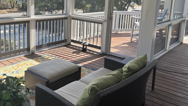 A covered outdoor deck with wicker furniture, a ceiling fan, and a view of a residential area. - Beautiful home in quiet beach neighborhood on canal. Five minute walk to beach. (Virginia Beach)