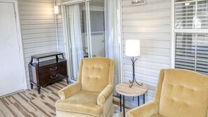 A room with two beige armchairs, a small wooden table with a lamp, and a dark wooden dresser. - Family friendly home near Colonial Williamsburg and Busch  Gardens (Williamsburg)