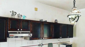 A kitchen with dark wooden cabinets, a gas stove, a microwave, and a kettle.