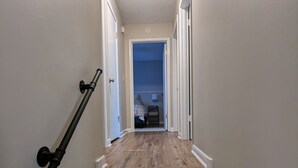 Una escalera de madera con paredes blancas y una lámpara en el techo.