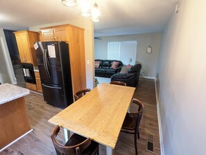 A compact kitchen with wooden cabinets and a black refrigerator.