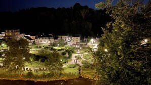Un barrio residencial con casas, un jardín iluminado y un río.