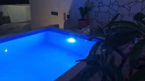 Une piscine éclairée de lumière bleue.