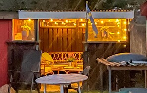 Enjoy a casual meal at this outdoor seating area with a rustic ambiance and comfortable seating for two.
