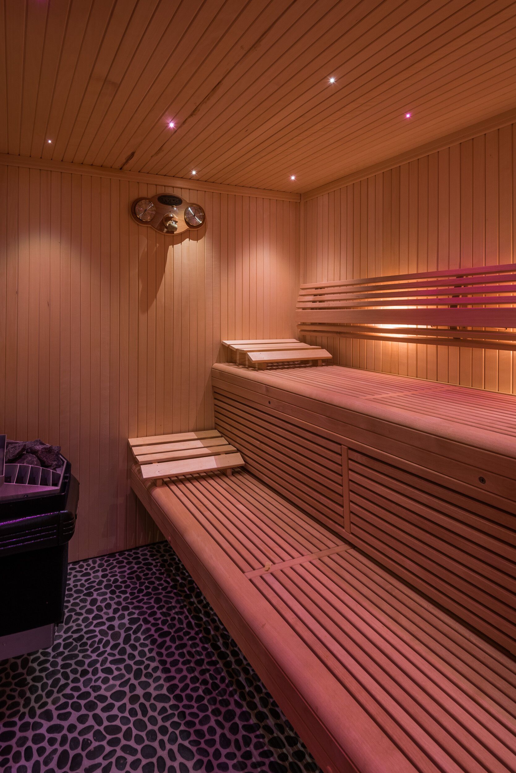 Eine Sauna mit Holzbänken und schrägverlaufender Decke.