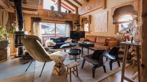 Ein gemütliches Wohnzimmer mit Kamin, Ledersofa und Fernseher.