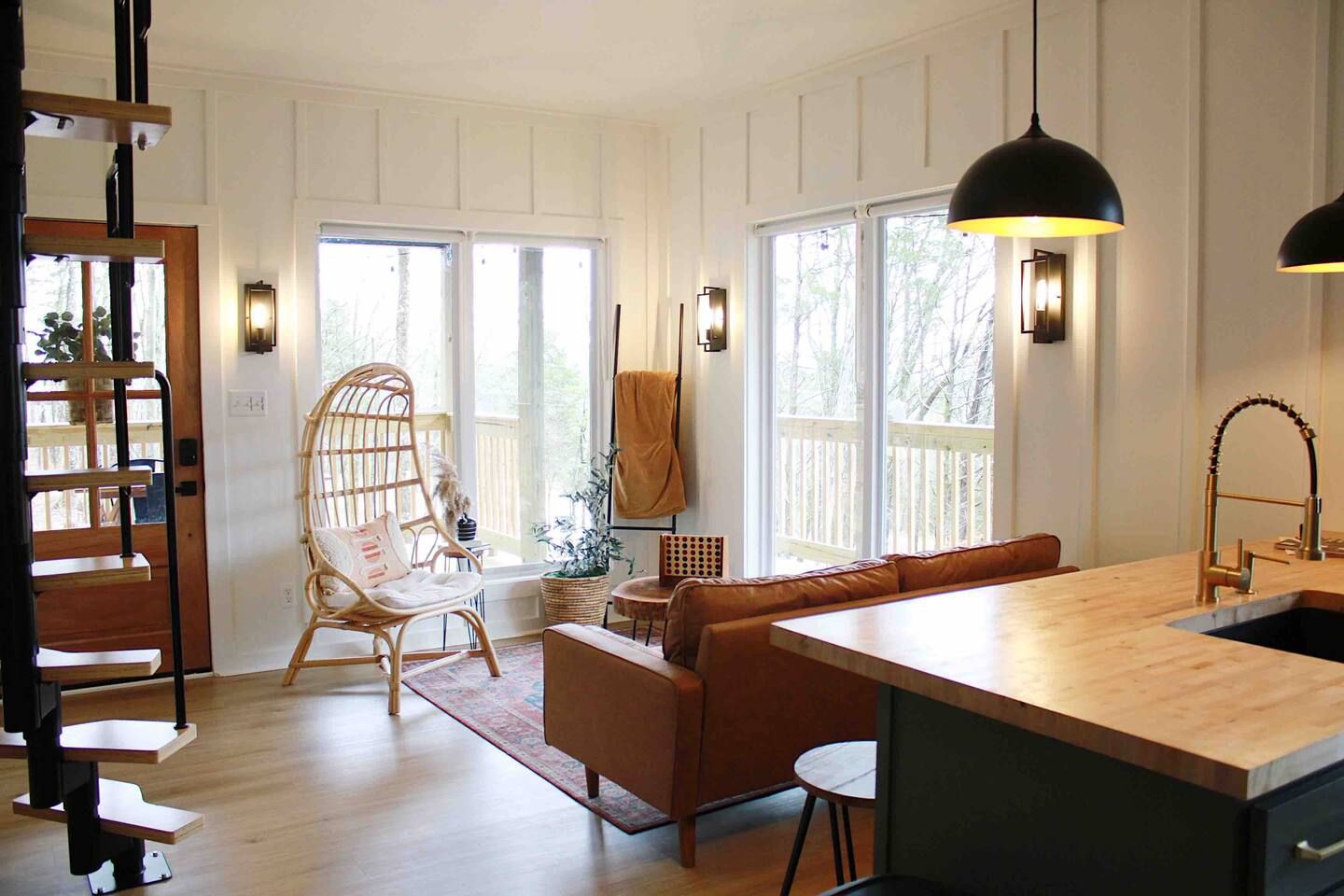 A spacious living area with a wooden bench, a sofa, and a dining table.
