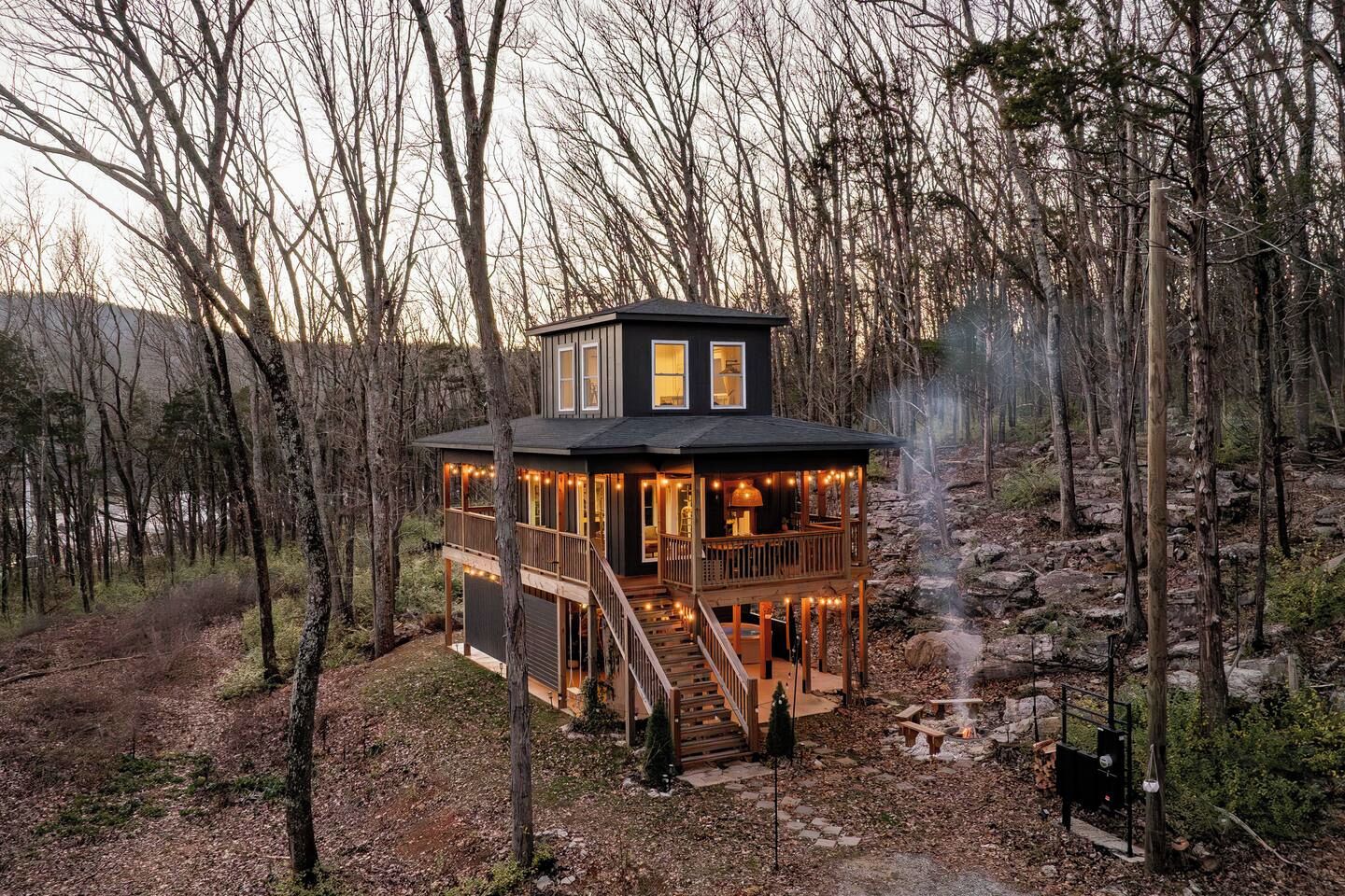 A cabin with a deck, a fireplace, and a stone pathway.
