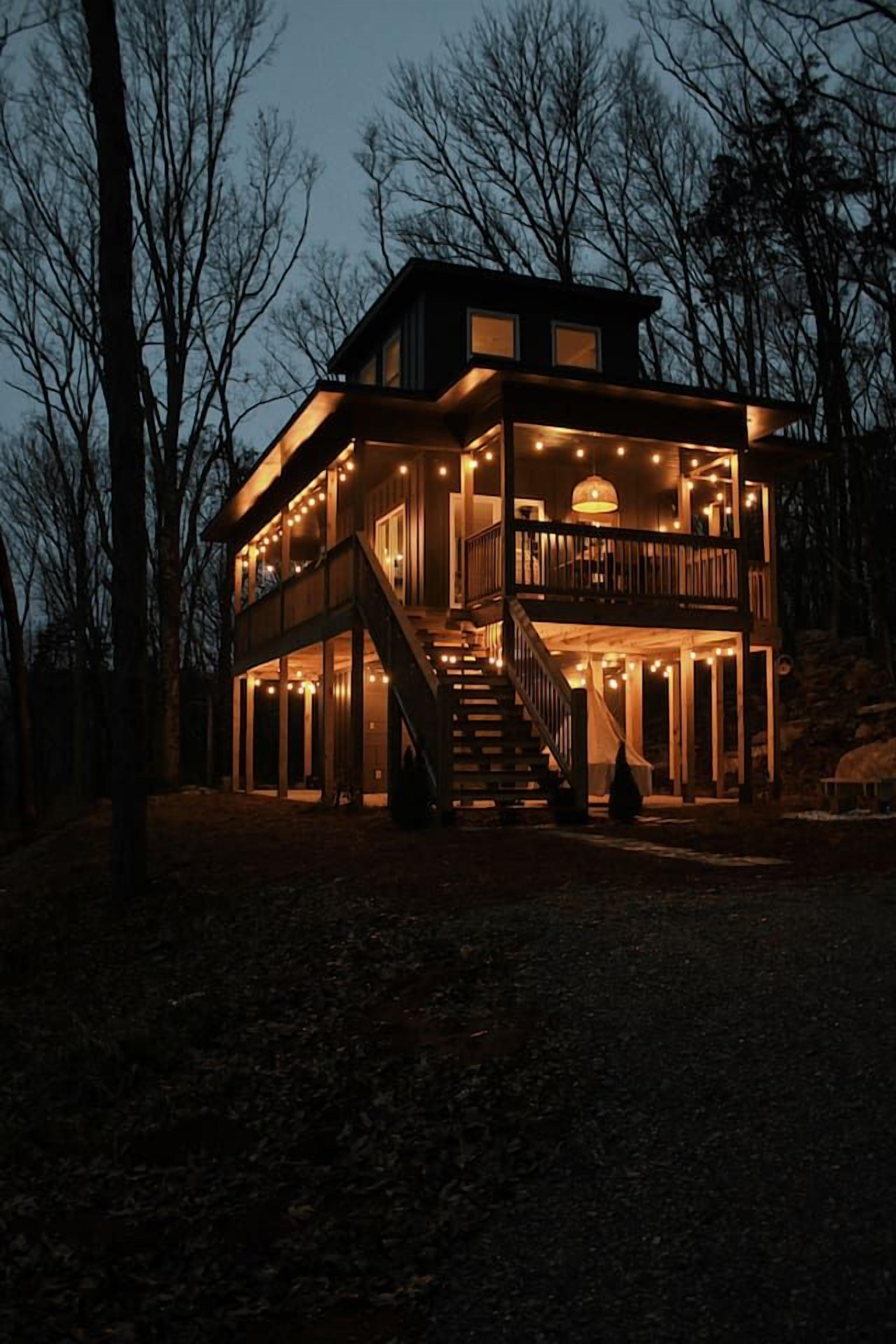 A two-story wooden house with a balcony and a staircase leading to the upper level.