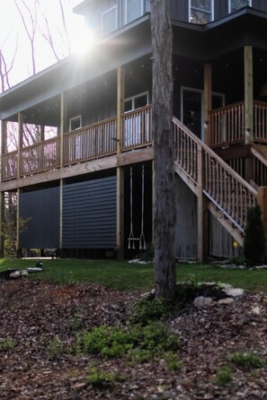 A multi-story building with a balcony, a staircase, and a garage door.