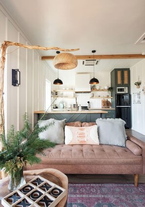 Una sala acogedora con un sofá, una mesa de centro y una planta decorativa.