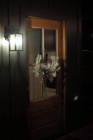 A wooden door with a frosted glass panel and a decorative wreath. - The Haven Treehouse-Luxury w/ hot tub & fire pit (Huntsville)