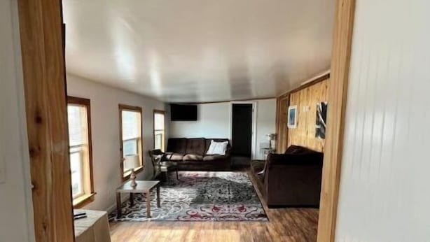 An open-plan living space with a high ceiling, wooden beams, and a large window. - Secluded Melrose Escape with Lake Access (Melrose)