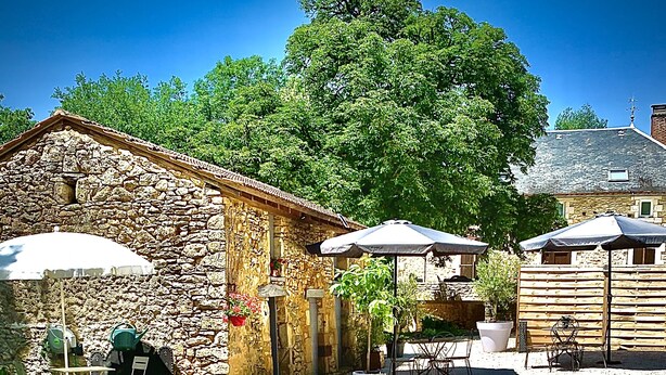 A stone building with outdoor seating and a small pond. - La biche au bois  (Montclera)