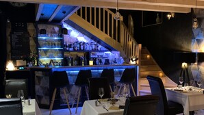 A restaurant with a bar area, multiple tables, and chairs. - La biche au bois  (Montclera)