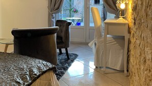 A room with a bed, a chair, a table, and a lamp. There is a window with curtains and a view of the outside. - La biche au bois  (Montclera)