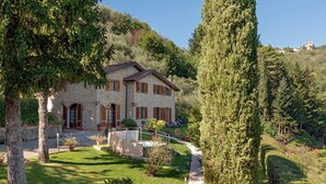 A stone house with a stone facade, wooden shutters, and a well-maintained lawn. - VILLA CAMELIA TUSCANY villa with pool surrounded by olive trees - wonderful view (Pescia)