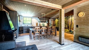 A modern kitchen with a dining area, wooden floors, and a large window.