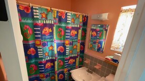 A bathroom with a colorful shower curtain, a sink, and a toilet.