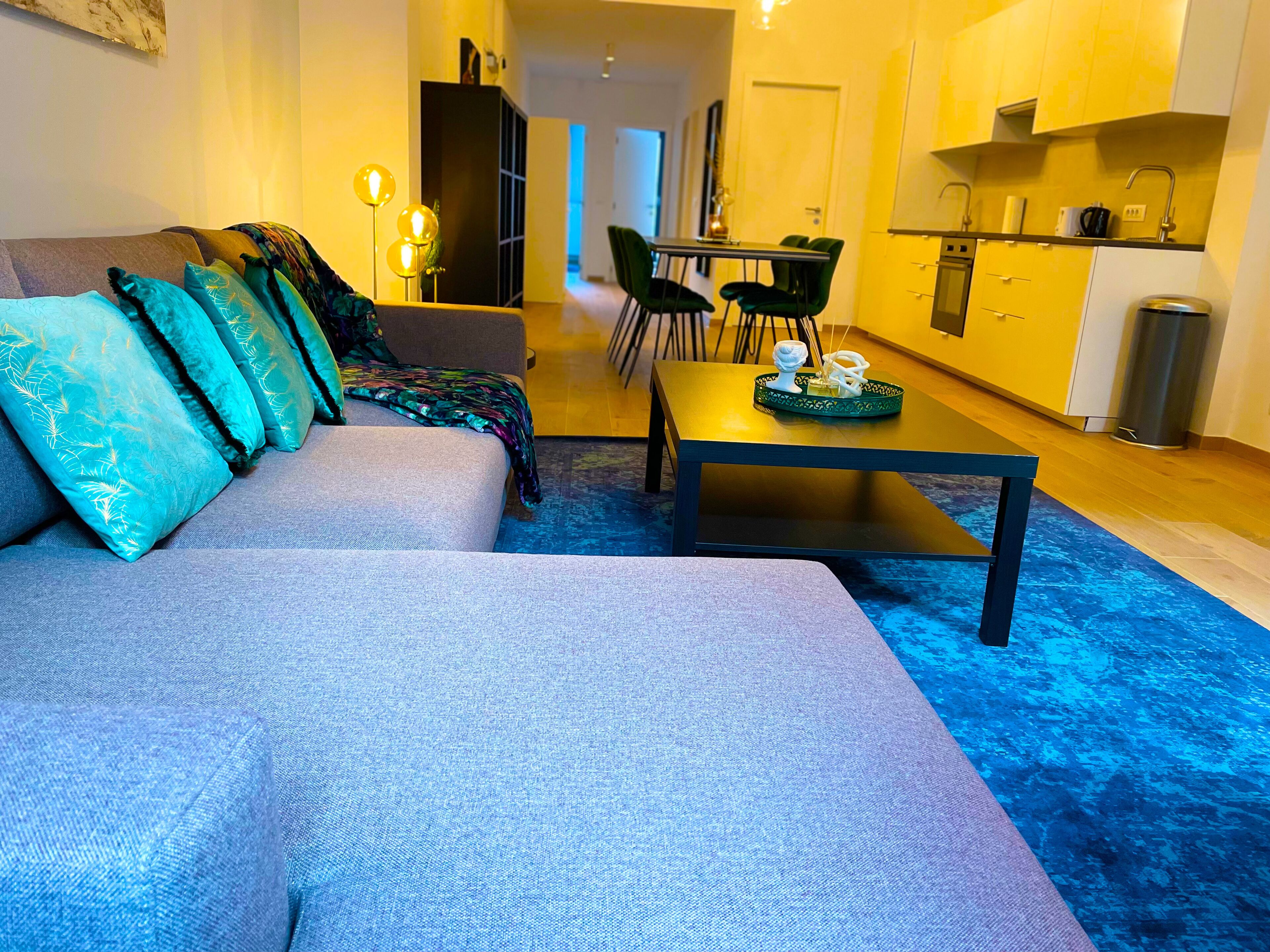 Een moderne woonkamer met een bank, een salontafel en een eethoek.