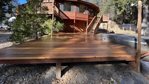 A wooden deck with a staircase leading to a second-story balcony. - Spacious Secluded Cabin on 9 acres Hot Tub Outdoor Dining Private Trails (Idyllwild-Pine Cove)