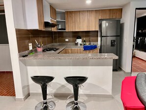 Signature Apartment | Private kitchen | Full-size fridge, stovetop, blender - Travelu (Guatapé)