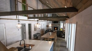 A modern kitchen with a large island, wooden beams, and pendant lighting. - Adirondack Lakefront Getaway-Newly renovated, fireplace, gameroom, close to Gore (Wells)