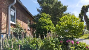 A brick building with a window and a stone wall. - "Haus Seegang" approx. 100 sqm, close to the beach and with a large garden (Neubukow)