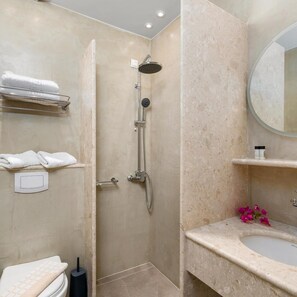 Een badkamer met een douche, toilet en wastafel.